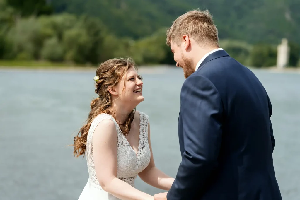 Brautpaar lacht gemeinsam am Rheinufer