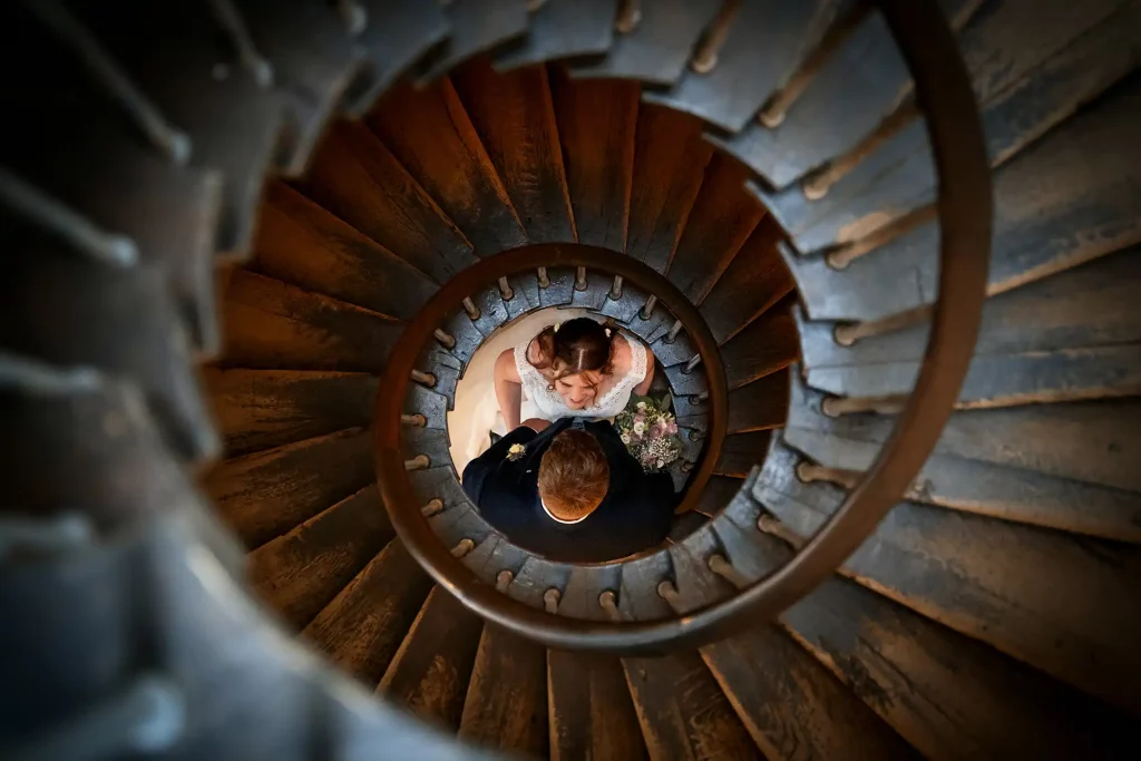 Brautpaar steht unter einer Wendeltreppe
