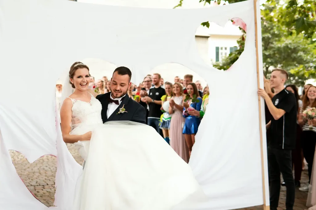 Bräutigam trägt Braut durch ein zuvor ausgeschnittenes Herz