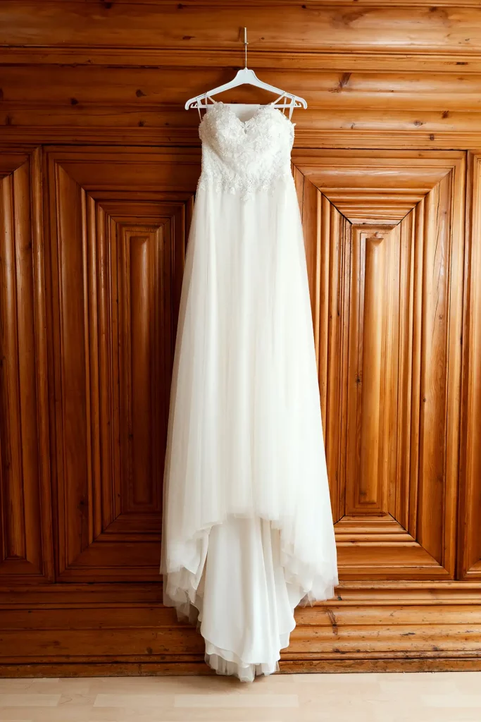 Brautkleid hängt am Kleiderhaken vor einem Schrank